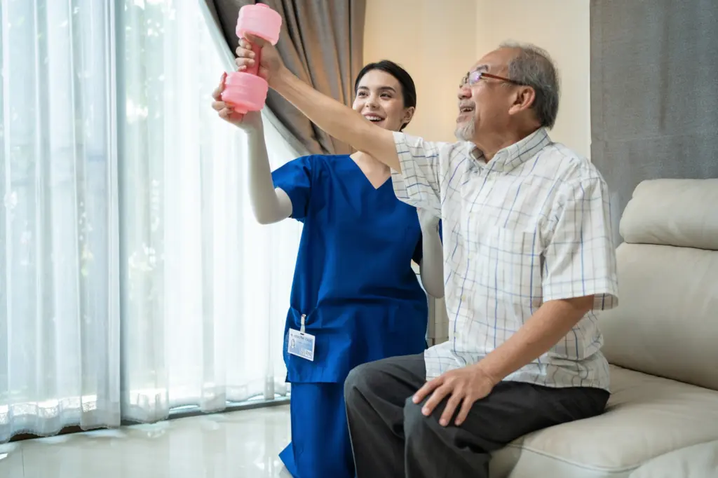 Asian nurse at nursing care support sick senior older man for therapy.