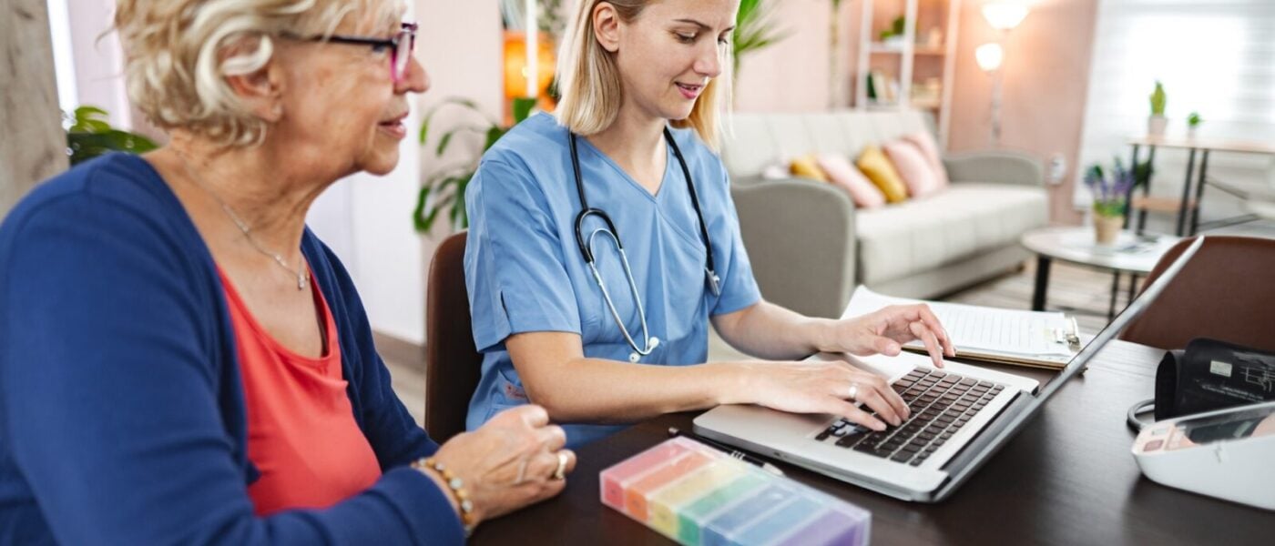 Healthcare professional assists patient at home visit