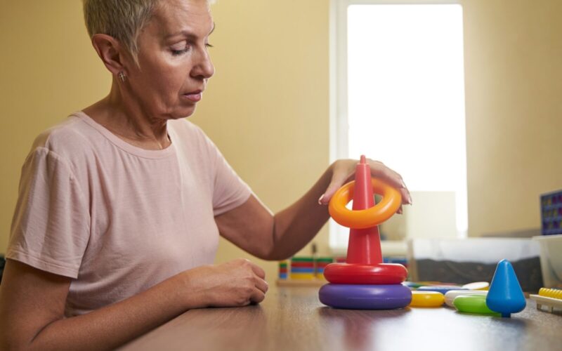 Photo of ergotherapy with stroke woman in rehab center